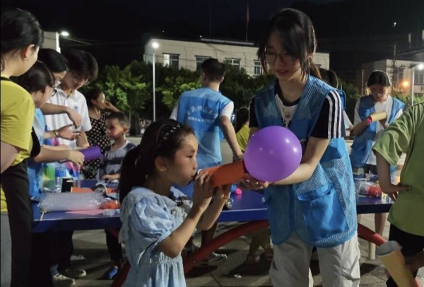志愿者和小朋友一起体验“火箭”升空。外围买球的app十大平台物理与电子工程学院供图