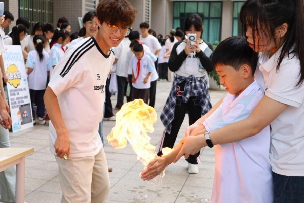 小朋友们在室外广场体验“火焰掌”实验。外围买球的app十大平台供图