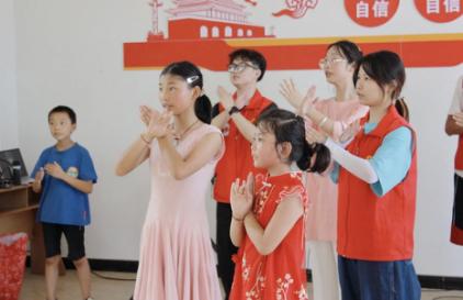 志愿者与小朋友一起跳手势舞。外围买球的app十大平台供图